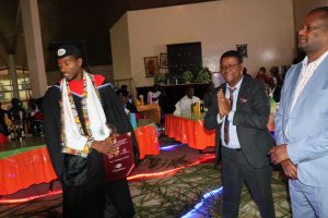 Student at graduation ceremony with Dr. feyera and Dr. Yeyis